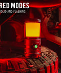 1000 Lumen USB C Rechargeable Emergency Camping Lantern in red mode on a tire showcasing solid and flashing red light feature