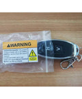 Car key fob with warning label on wooden surface, highlighting ingestion hazard.