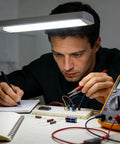 Person testing a circuit on a breadboard with a multimeter, using 840 Piece Jumper Wire Kit for Solderless Breadboard with 14 Lengths U Shape Wires