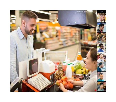 A cashier interacting with a customer at a grocery store checkout with fruits and beverages visible.