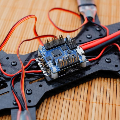 RC flight controller mounted on drone frame with wiring, showing anti vibration rubber balls set for F4 and F7 M3x8mm mounting.