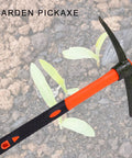 Heavy Duty Miniature Pick Mattock With Fiberglass Handle Garden Tool in garden soil with seedlings visible nearby.