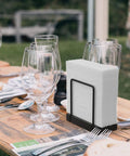 Table Top Napkin Holder Made of Bamboo and Iron, Standing Dispenser for Kitchen and Dining, Rustic Black Finish on a picnic table