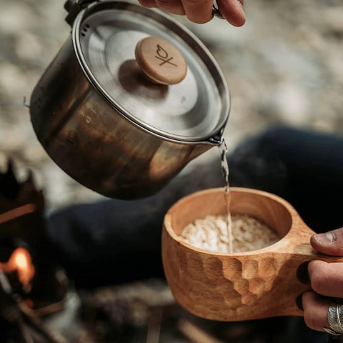 Kuksa Wooden Cup Handcarved 8 Oz Coffee Mug With Lanyard And Carabiner held while pouring from kettle