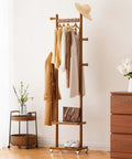 Freestanding Walnut Wood Coat Rack With Wheels, 5 Heavy Duty Hooks holding clothes, 2 Shelves with decor, in corner room setup.