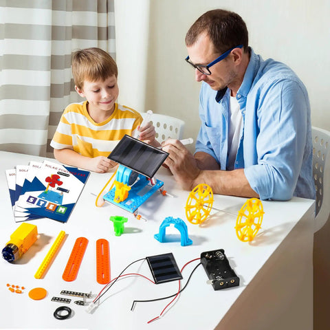 4-In-1 Solar Robot Kit For Kids Ages 8-12, STEM Toys For Boys And Girls, Solar Powered Fan Car And Robot, Pulley Powered Tank, Hands-On Electricity, Mechanics And Engineering Projects For Real World Learning on table with boy and man