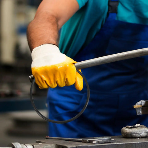 Built Tough Rubber Belt Pack For 770 And 900 Continuous Sealers being held in a gloved hand in a workshop setting.