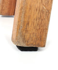 Close-up of a wooden table leg with black rubber feet pad from 48 Pack Black Rubber Feet Pads Self-Adhesive Furniture Protectors For Wooden Floors And Surfaces, Prevent Scratches And Dents, Slick Glide With 2.1 Cm Size, Durable Non Slip Cushions.
