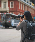 Person using Walker Pro 24L Camera Backpack For Photography And Video Gear With Front Panel Access All Day Comfort in urban area