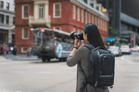 Person using Walker Pro 24L Camera Backpack For Photography And Video Gear With Front Panel Access All Day Comfort in urban area