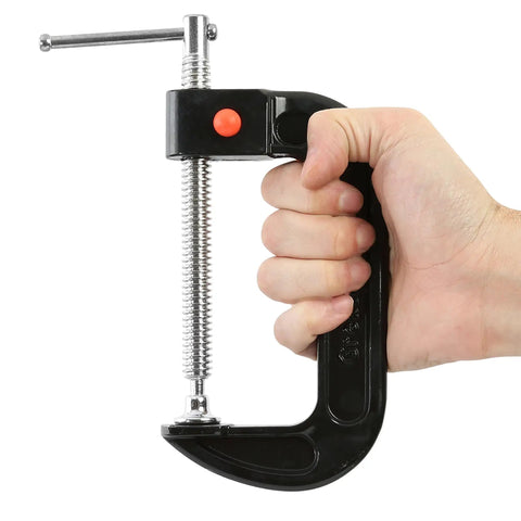 Hand holding 4 Inch Quick Release C Clamp with Push Button Release, Steel Swivel and Screw for Auto Repair, Welding, and Woodworking