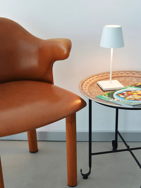 Poldina Pro Mini Rechargeable Wireless Table Lamp With Touch Control on round table beside brown chair
