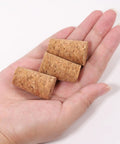 Hand holding three 25 Pack Natural Soft Wood Corks, Tapered Bottle Stoppers For Wine Making And DIY Crafts, Leakproof, Reusable