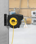 Heavy Duty Retractable Extension Cord Reel 50 Feet Long With Rugged 14 AWG Wiring mounted on wall with three outlets visible.
