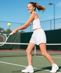 Girl playing tennis wearing Girls Quick Dry Athletic Shorts With Liner For Running, Soccer, And Volleyball, Lightweight Breathable Fabric, Zip Pockets, Soft Mesh Liner, 11-12 Years, White.