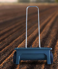 Hand Push Seed Spreader For Lawn And Garden, Walk Behind Drop Spreader Tool on freshly tilled soil