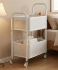 Rock Solid Two Tier Rolling Storage Cart With No Sweat Mobility And Compact Perforated Metal Baskets Ideal For Living Rooms Offices And Daily Grind featuring white metal baskets next to a bed.