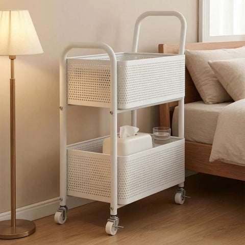 Rock Solid Two Tier Rolling Storage Cart With No Sweat Mobility And Compact Perforated Metal Baskets Ideal For Living Rooms Offices And Daily Grind featuring white metal baskets next to a bed.