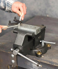Rock Solid Five Inch Workbench Vise With Knockout Grip Smooth Non Marring Jaws and Heavy Duty Locking Mechanism in use for clamping.