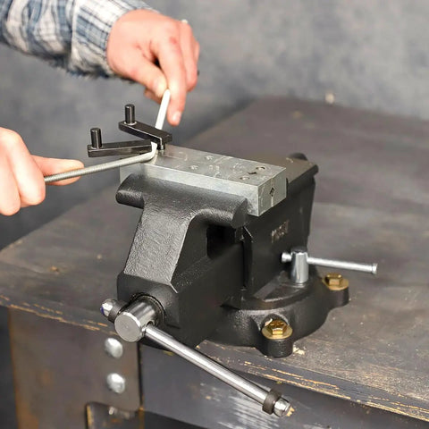 Rock Solid Five Inch Workbench Vise With Knockout Grip Smooth Non Marring Jaws and Heavy Duty Locking Mechanism in use for clamping.