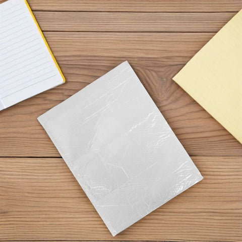Waterproof Bubble Mailers 10 Pack Self Seal Padded Envelopes 40x50 CM on wooden surface with notebooks visible