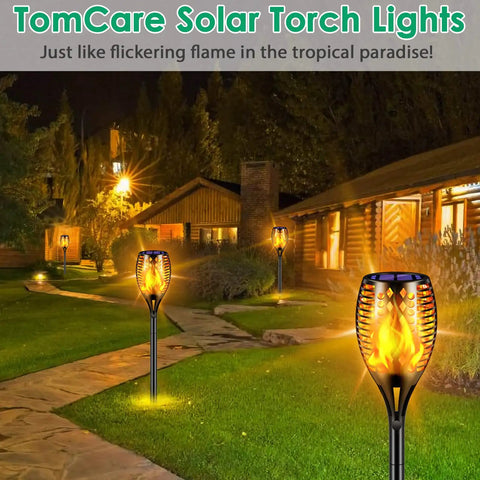 Outdoor scene with 43 Inch Solar Flameless LED Torches With Flickering Flame Effect lighting a garden path at night.