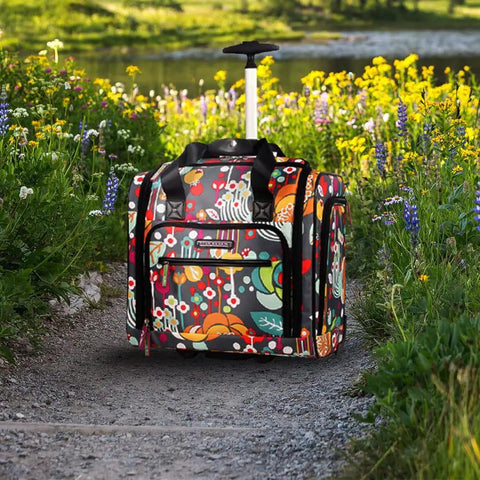 Underseat Carry On Rolling Bag For Women, 15 Inch Lightweight Weekender Luggage on path, floral pattern, telescoping handle extended.
