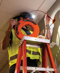 High Flex 75 Foot Tri Strand Polyester Fish Tape For Smooth Electrical Wire Pulling used by a worker on a ladder with headlamp.