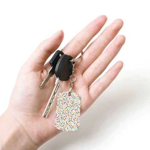 Slick Mini Abstract Rectangle Aluminum Keychain Featuring A Dope Scattered Grid Plated Finish Rust Resistant Metal Key Holder And Bag Charm Daily Accessory For Her And Him held in hand.