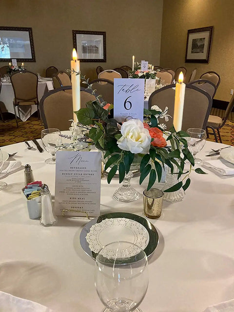 Table setting with Battery Operated Flameless Taper Candles With Remote And Timer, Realistic 3D Flickering Flame next to floral centerpiece.