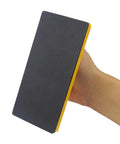 Close-up of hand holding a Two Pack Safety Push Block Set With High Visibility No Slip Grip for woodworking, showing textured grip surface.