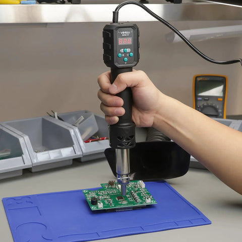 Hand using Multi Purpose Heat Gun For Crafts And DIY Projects With Adjustable 212F To 932F Air Temperature on circuit board