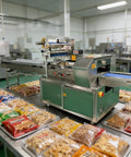 Smooth Operator Compact Horizontal Flow Pack Machine Small Shrink Wrapper Rock Solid Performance 50 To 80 Wraps Per Minute in a busy food packaging environment.