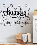 Laundry Room Wall Decal Set With Wash Dry Fold Repeat Bubble Stickers Funny Sign For Home Decor Easy Peel And Stick Removable Black Wall Art Large 19.7 By 30.7 Inches displayed above a laundry basket and washing machine.