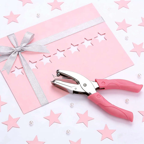 Pink star hole puncher next to decorated cardstock; Two Pack Handheld Heart And Star Shape Hole Punches With Ergonomic Soft Grip, 5mm Star And 5.5mm Heart Puncher For Paper Crafts, Scrapbooking, Tags, Tickets, DIY Projects, Pink And Green.