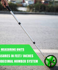 Six Inch Measuring Wheel With No Fuss One Key Reset Telescopic Mechanical Distance Meter measuring on a pavement.