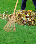 Lightweight Bamboo Rake With Wooden Handle For Leaves And Lawn, 23.4 Inch Hand Rake in use on green grass and leaves