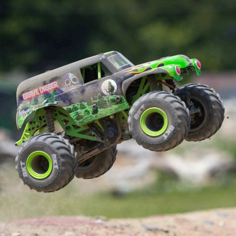 Grave Digger 1 To 18 Scale Mini LMT 4X4 RC Monster Truck RTR with green body and LED headlights performing a jump outdoors