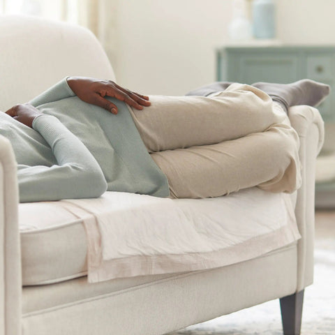 Person resting on sofa with Heavy Absorbency Underpads 30 x 36 Inches Disposable Bed Pads 100 Count For Incontinence, Ultra Protection