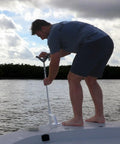 Man using Heavy-Duty Bow Mount Anchor For Shallow Water Deployment, Marine-Grade Aluminum Deck Mount With Black Powder Coat on boat
