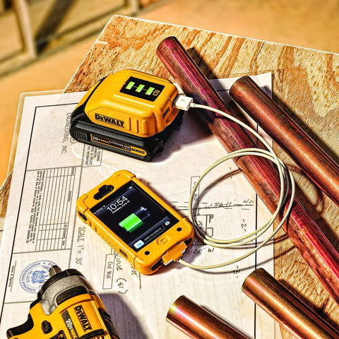 12V And 20V Max USB Charger With Two Ports And State Of Charge Indicator For The Job Site Powers Two USB Devices From 12V Or 20V Max Batteries When AC Power Is Not Available And Is Compatible With Slide Style Battery Packs on a workshop table.