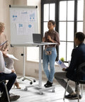 Mobile T Shaped Pneumatic Height Standing Desk On Lockable Wheels Sit To Stand Adjustable Desk For Home Office, in use during meeting.