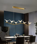 Badass Brass Bird Pendant Light Slick Modern Ceiling Fixture With Ultra Smooth Lighting And Zero Glare For Restaurants Bedrooms Offices And Hotel Hallways Game Changing Room Decor above dining table in modern setting.