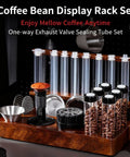 Keep Your Grounds Fresh As A Bell With This Six Tube Single Dose Coffee Bean Storage Jar Set Featuring One Way Exhaust Valves And A Smart Hopper For Flawless 22 To 25 Gram Portions To Brew On Point Daily, displayed with glass tubes and wood rack.