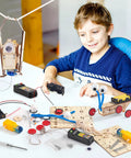 Child assembling models from Five In One Hands On STEM Robot Kit For Kids Aged 8 to 12 with wood building crafts visible