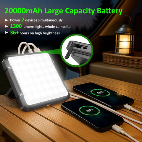 Rechargeable 20000mAh LED Camping Lantern With 1300 Lumen Brightness charging two phones on a wooden table.