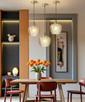 Top Shelf Amber Glass Pendant Light With Vintage Gold Trim For Kitchen Island And Dining Area Height Adjustable Cord Fits Dimmable E26 Bulbs above a dining table with flowers.