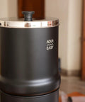 2.25 Gallon Gravity Water Filter System With Dual Activated Carbon Filters, matte finish, stainless steel tap on wooden countertop position.
