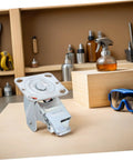 Rugged Steel Swivel Caster Bracket With Locking Brake And Four Inch Wheels on workbench with tools in background.