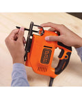 Versatile 4.5 Amp Corded Electric Jigsaw Delivering Killer Wood And Metal Cuts With Variable Speed Up To 3000 Spm, held by hands with blade attached.